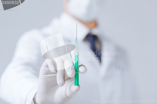 Image of male doctor holding syringe with injection