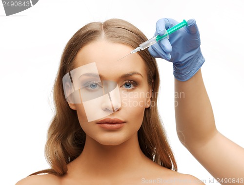 Image of woman face and beautician hands with syringe