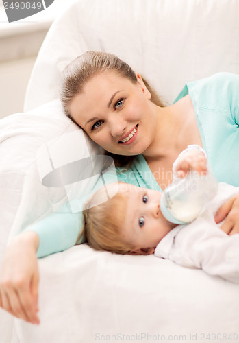 Image of mother and adorable baby with feeding-bottle