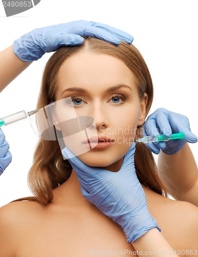 Image of woman face and beautician hands with syringe