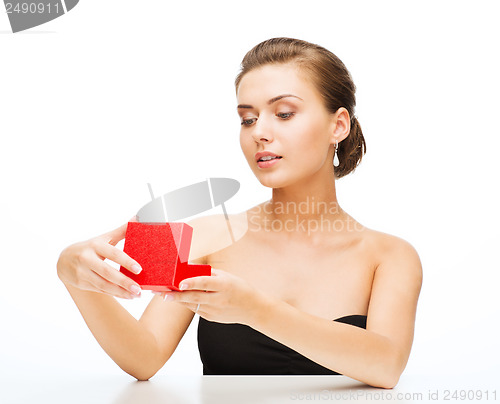 Image of woman with earrings, wedding ring and gift box