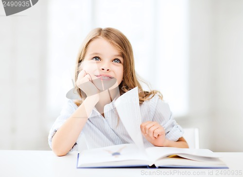 Image of little student girl studying at school
