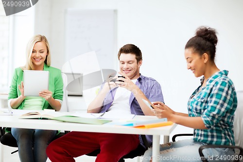 Image of students looking into devices at school