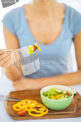 Image of woman hand holding fork with vegetables