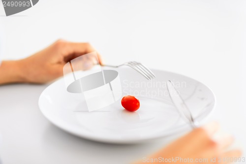 Image of woman with plate and one tomato