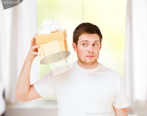 Image of man in white t-shirt with gift box