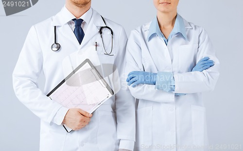 Image of nurse and male doctor holding cardiogram