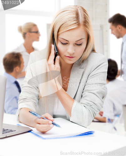 Image of businesswoman with phone in office