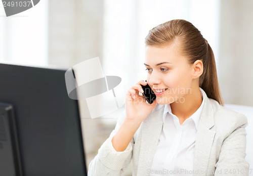 Image of businesswoman with smartphone in office