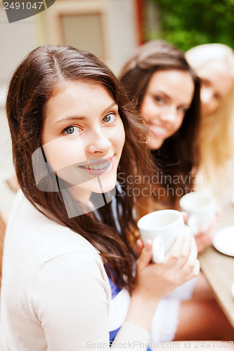 Image of beautiful girls drinking coffee in cafe