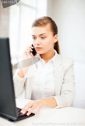 Image of businesswoman with smartphone in office