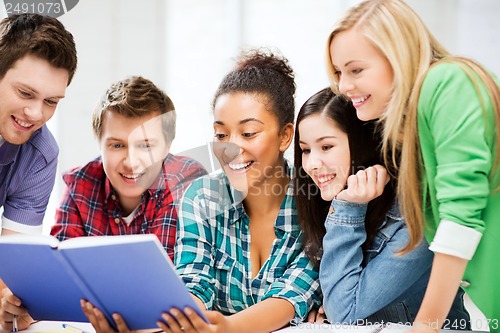 Image of students reading book at school