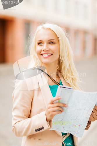 Image of girl looking into tourist map in the city