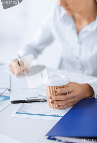 Image of woman with coffee filling in blank paper