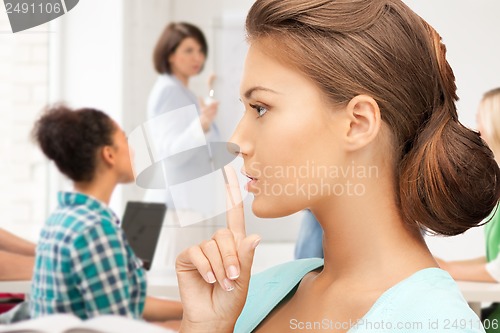 Image of student making hush gesture at school