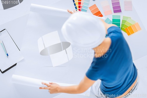 Image of woman with color samples and blueprint