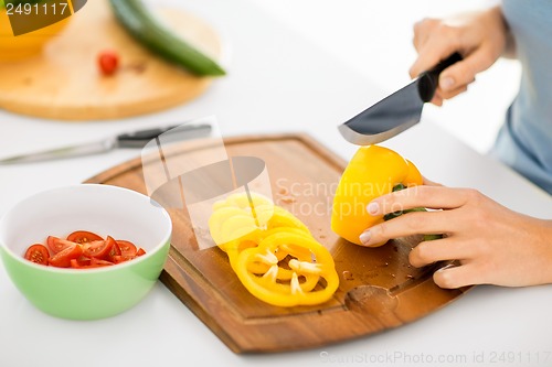 Image of woman hands cutting vegetables