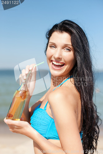 Image of girl with bottle of drink on the beach