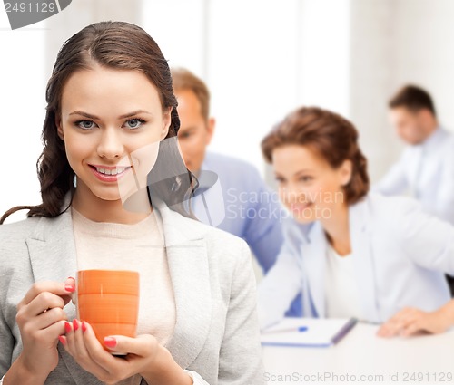 Image of beautiful businesswoman with cup of coffee