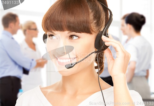 Image of helpline operator with headphones in call centre