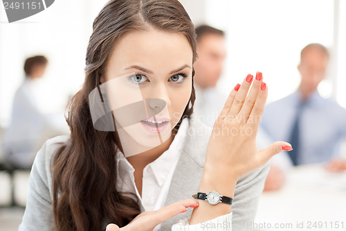 Image of businesswoman pointing at her watch