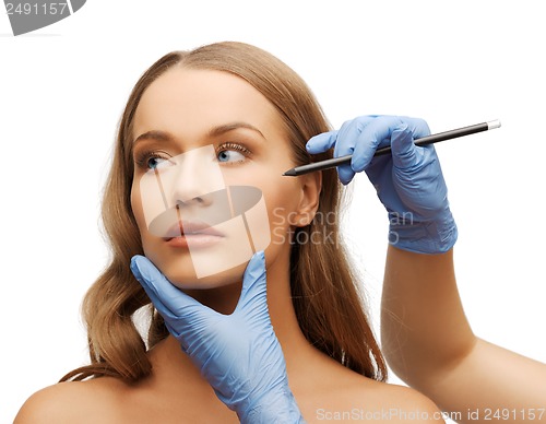 Image of woman face and beautician hands with pencil