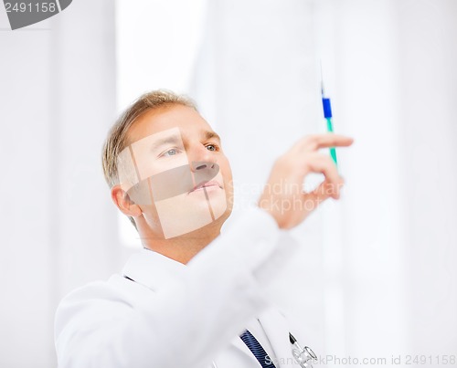 Image of male doctor holding syringe with injection