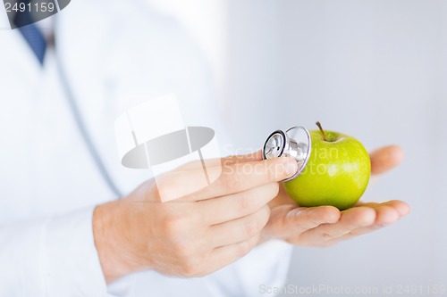 Image of male doctor with green apple and stethoscope