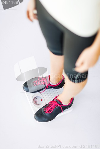 Image of woman legs standing on scales