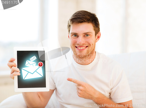 Image of man holding tablet pc with email sign at home