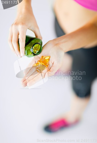 Image of woman hand with capsules