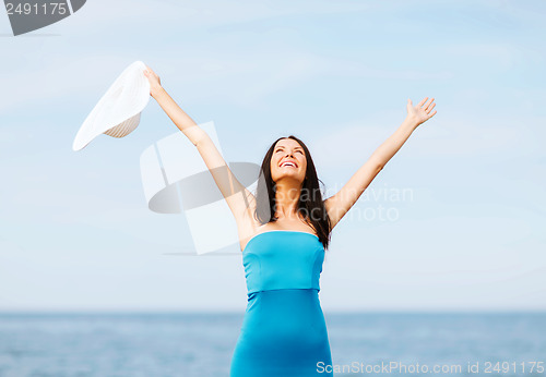 Image of girl with hands up on the beach