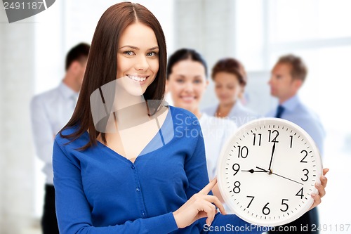 Image of businesswoman pointing at alarm clock