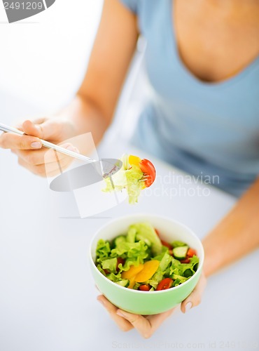Image of woman eating salad with vegetables