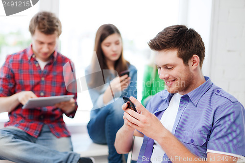 Image of student looking into smartphone at school