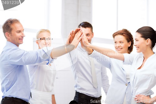 Image of business team celebrating victory in office