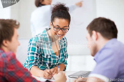 Image of african student writing something in notebook
