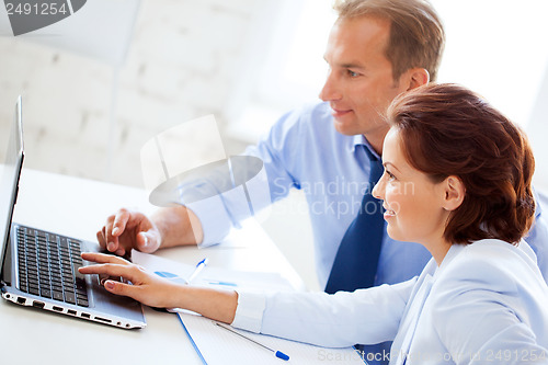 Image of man and woman working with laptop in office