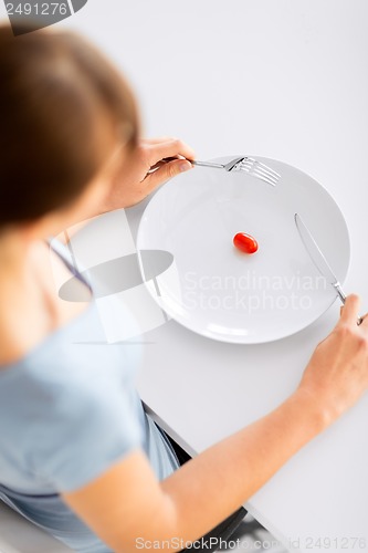 Image of woman with plate and one tomato