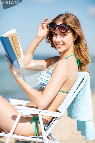 Image of girl reading book on the beach chair