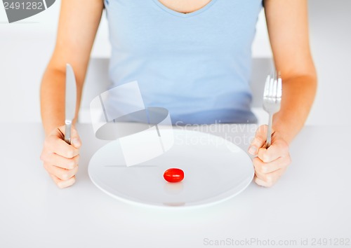 Image of woman with plate and one tomato