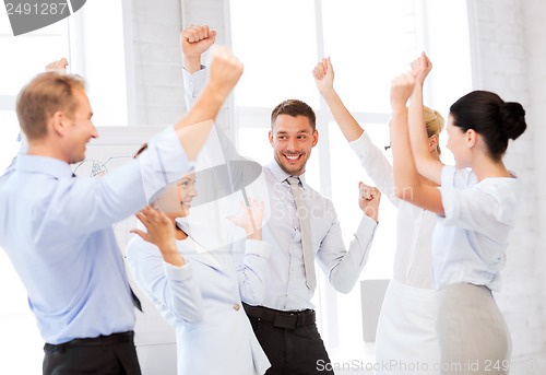 Image of business team celebrating victory in office