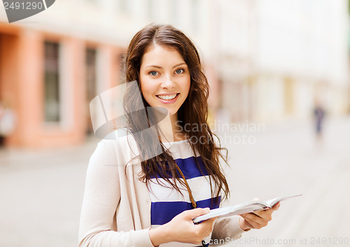 Image of girl looking into tourist book in the city