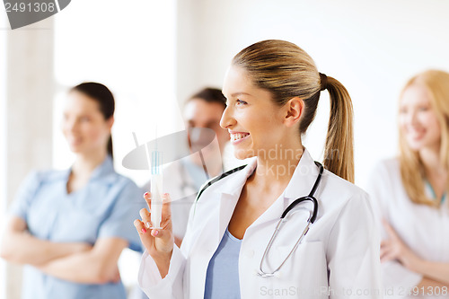 Image of female doctor holding syringe with injection
