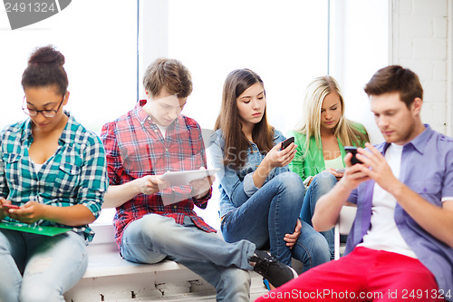 Image of students looking into devices at school