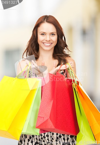 Image of woman holding color shopping bags in mall