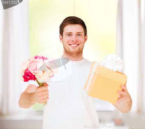 Image of man holding bouquet of flowers and gift box