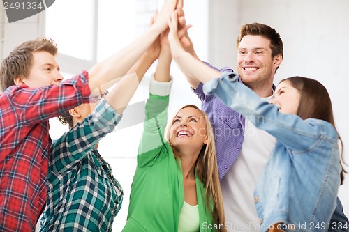 Image of happy students giving high five at school