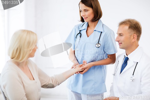 Image of nurse with patient measuring pulse