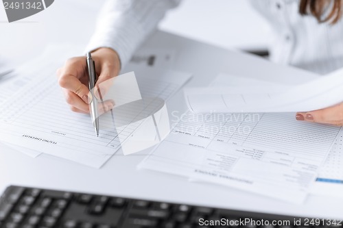 Image of woman hand filling in blank paper or document